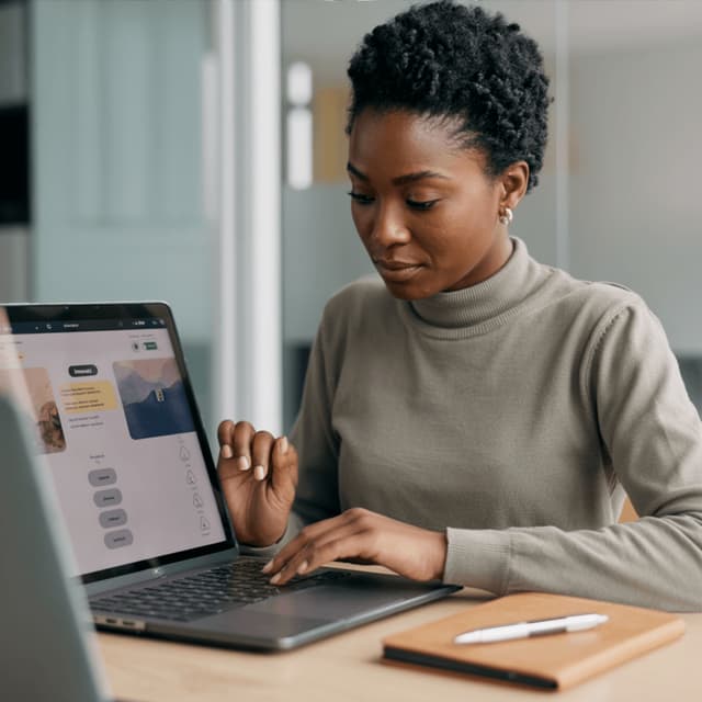 Amara Okafor seated behind a laptop.