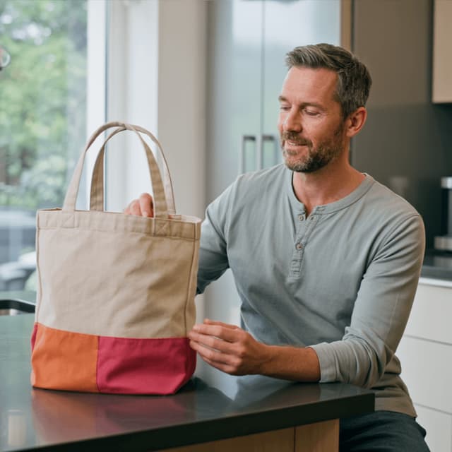 Hugo Bennett seated at a table with a canvas goodie bag