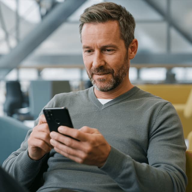 Hugo Bennett looking at a phone while seated in an office