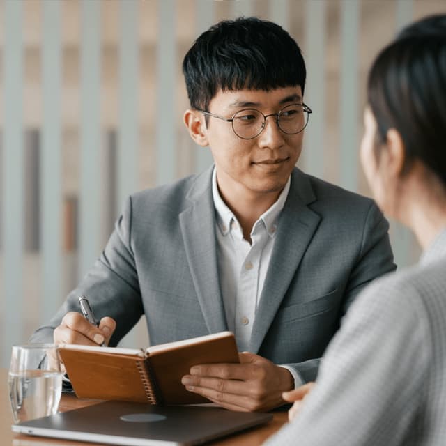 Min-jun Park seated at a meeting table with colleagues