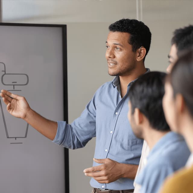 Rafael Nascimento standing at a whiteboard during a meeting