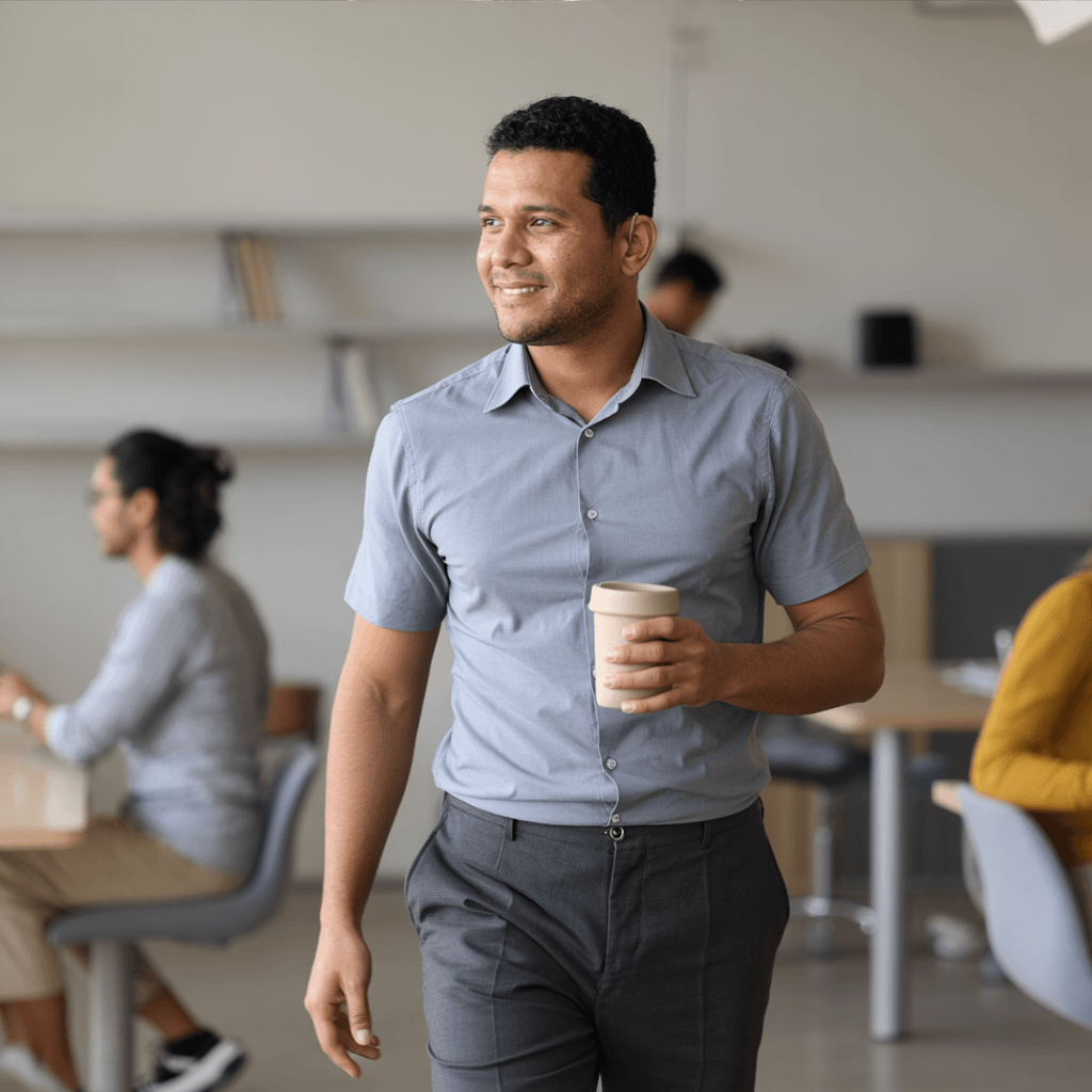 Rafael Nascimento walking through the office with coffee